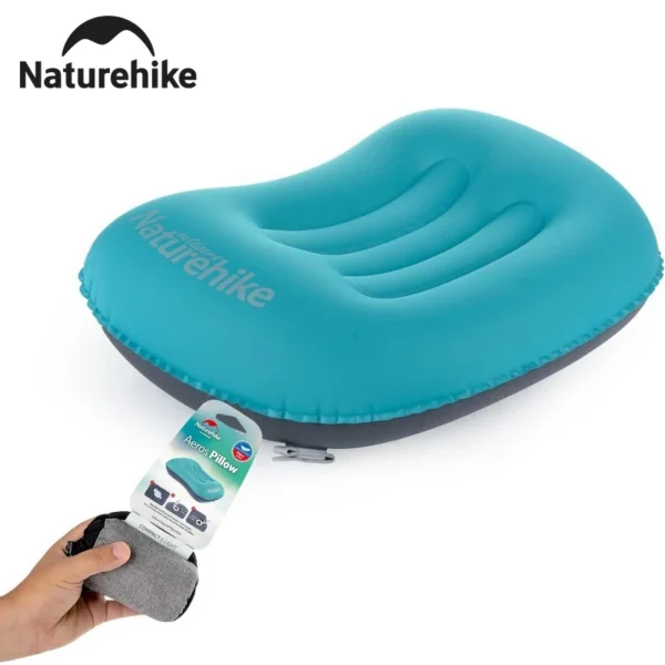 Ultralight inflatable camping pillow in orange resting on a sleeping bag inside a hiking tent