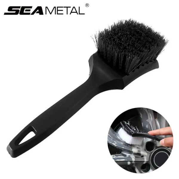Tire rim cleaning brush with black handle scrubbing a dirty alloy car wheel