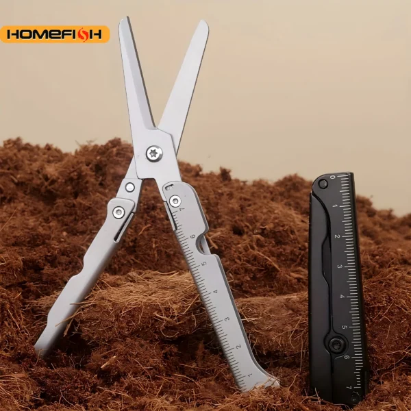 Folding camping scissors in silver steel opened next to a coil of cord on a camp table