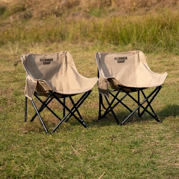 Yellow Oxford folding moon chair set up beside a tent at a campsite