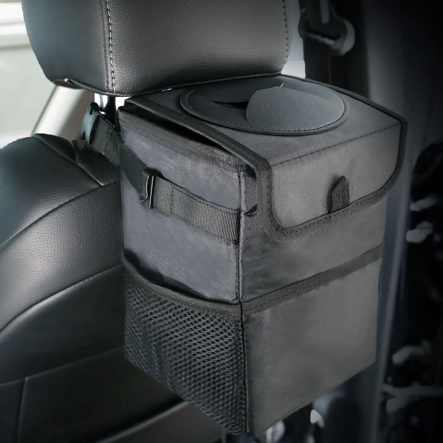 Lidded Car Trash Can 3 in 1 Leakproof Storage Bag for Cars 1 Black lidded car trash can hanging on a car seat back with the lid closed