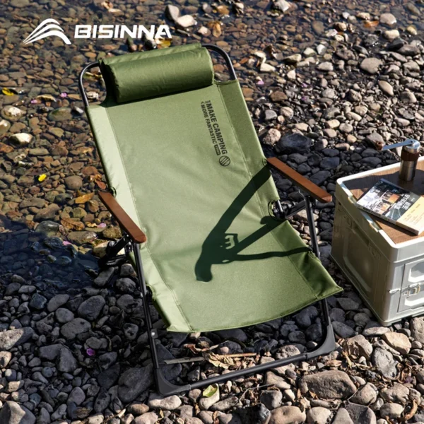 BISINNA folding camping lounge chair in green with armrests set up at a campsite