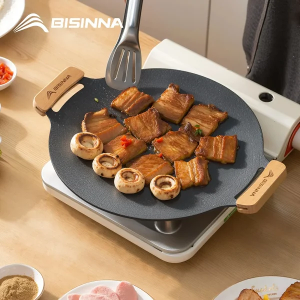 Large camping grill plate 34cm with non-stick surface and wooden handles, viewed from above