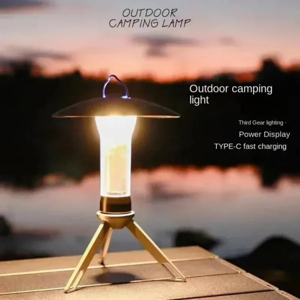 Tripod camping lantern standing on its bracket and lighting up a tent and camp table at night