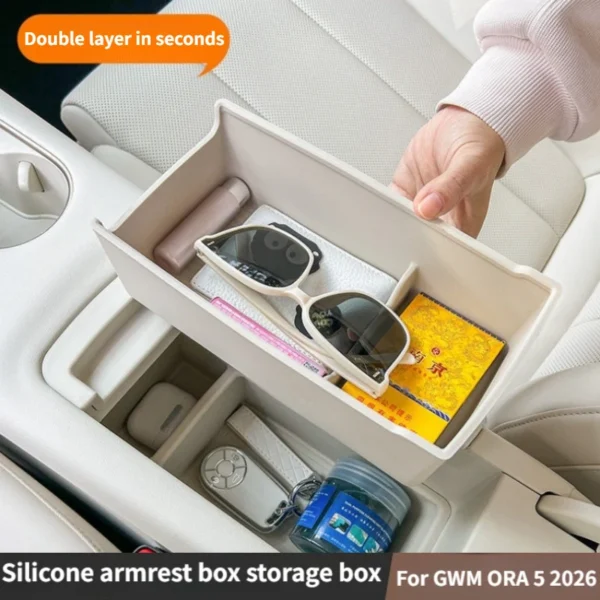 Black silicone layered armrest storage box inside the center console of a GWM ORA 5
