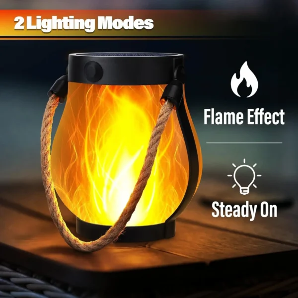 Solar flame lantern hanging from a tree branch at a campsite with a warm flickering glow
