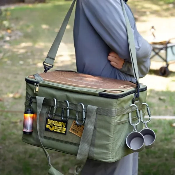 Khaki camping table storage bag with wooden top board, set up at a campsite with food prep