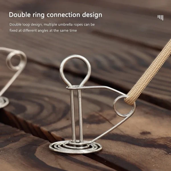 Spiral deck tent stakes twisted into a wooden platform gap anchoring a tent guy rope