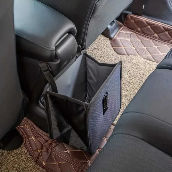 Collapsible car trash can hanging on the back of an SUV seat with the lid open