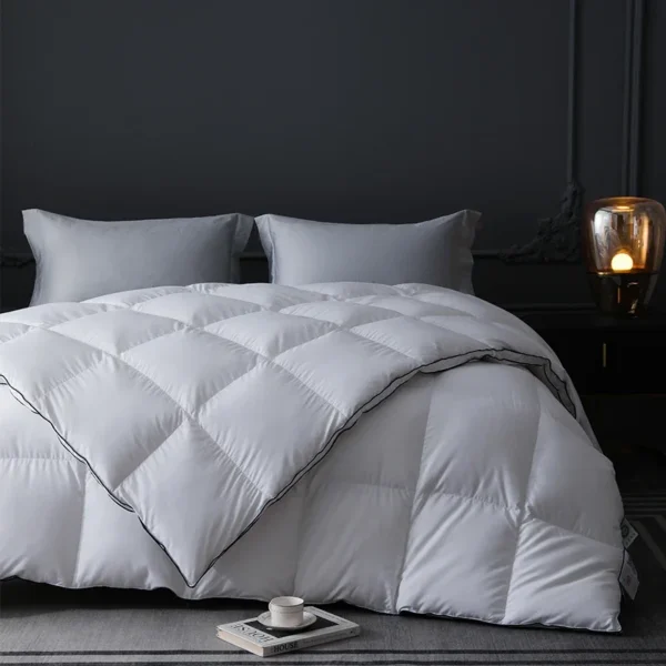 White quilted goose down comforter spread over a bed showing its evenly filled square grids