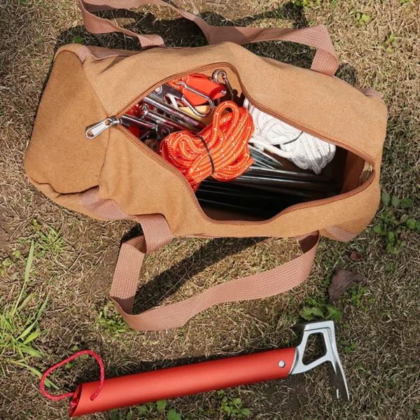 Cylindrical canvas tool bag in khaki holding tent stakes and ground pegs beside a tent