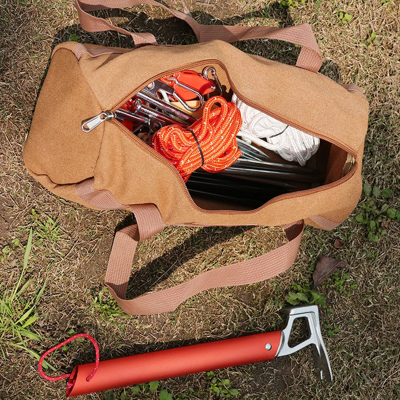 Cylindrical Canvas Tool Bag for Tent Stakes and Ground Pegs 1 Cylindrical canvas tool bag in khaki holding tent stakes and ground pegs beside a tent