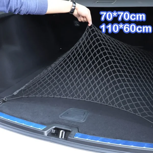 Black elastic trunk cargo net with hooks stretched over grocery bags and a ball in a crossover trunk
