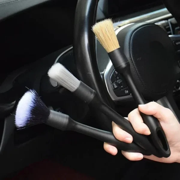 Synthetic wool detailing brush set of three cleaning dust from a car air vent