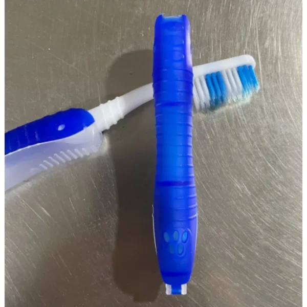 Folding travel toothbrush in light blue shown open and closed beside a camping toiletry bag