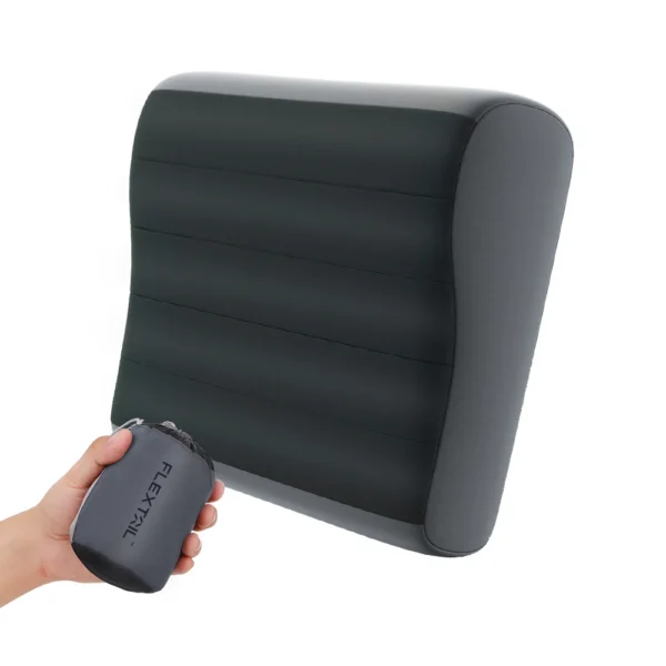Adjustable height camping pillow inflated on a sleeping pad with its small stuff sack nearby