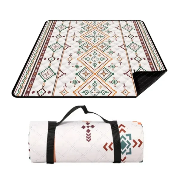 Large waterproof picnic blanket in oxford fabric spread on grass with its carrying handle folded