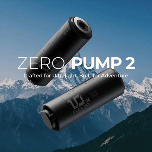 Mini sleeping pad inflator in aluminum held in one hand next to a rolled sleeping pad