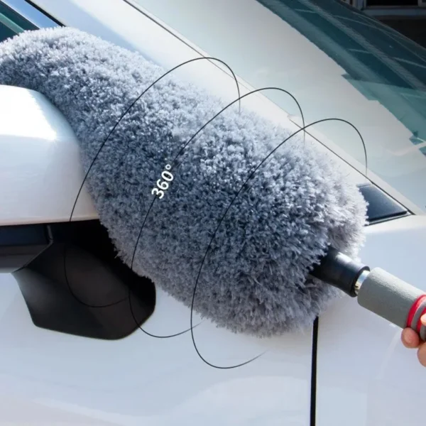 Telescopic car duster brush with microfiber head sweeping dust off a car roof