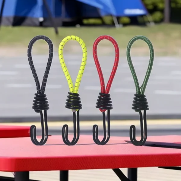 Rubber tent bungee cords in yellow with coated hooks fastening a tent fly to stakes