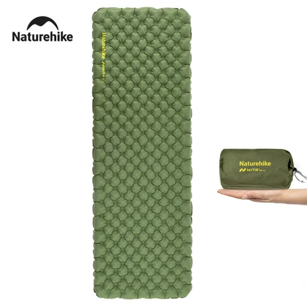 Ultralight camping air mattress with square ends inflated on a beach next to its small storage bag