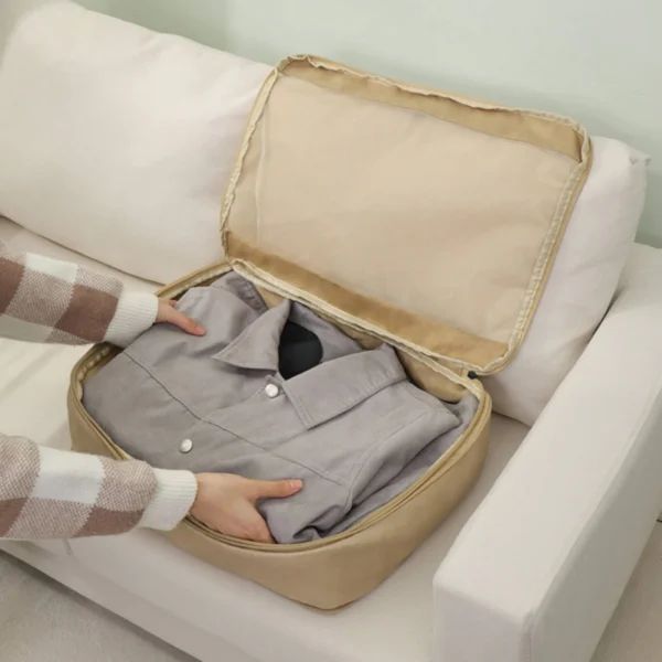 Gray pp compression packing cube with mesh panel and zipper, packed with folded clothes
