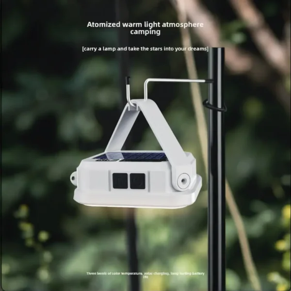 Solar emergency light with battery display hanging by its hook in a tent while charging a phone