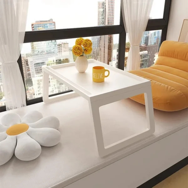 Foldable laptop bed table in grey with folding legs holding a laptop on a bed