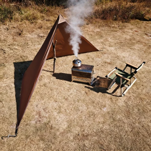 Canvas stove windscreen standing around a camping stove on a picnic table outdoors