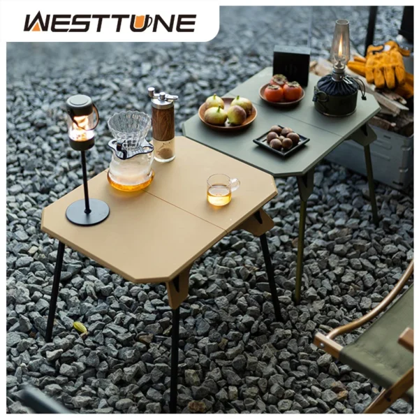 Dual height camping table with folding aluminum legs set up outdoors next to its storage bag