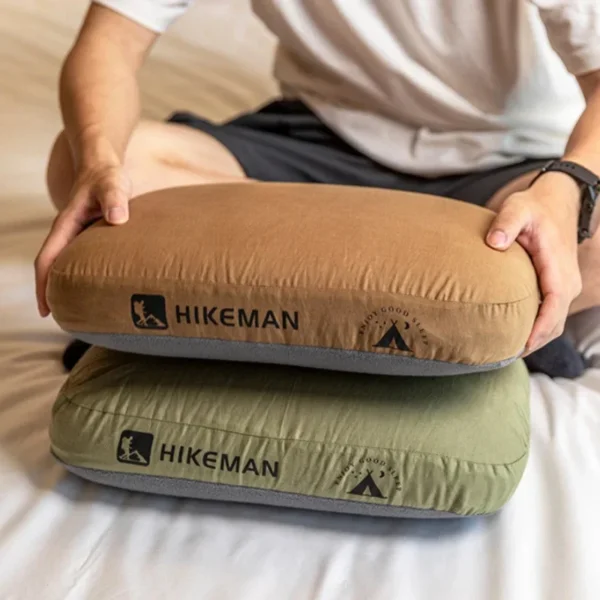 Memory foam travel pillow in gray with cotton case and storage bag on a camping mat