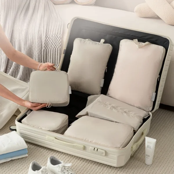 Travel clothes storage bags set in beige polyester with clothes and shoes in a suitcase