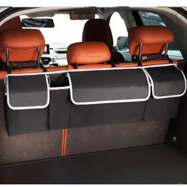 Hanging car trunk organizer with four pockets strapped to the back of rear seats