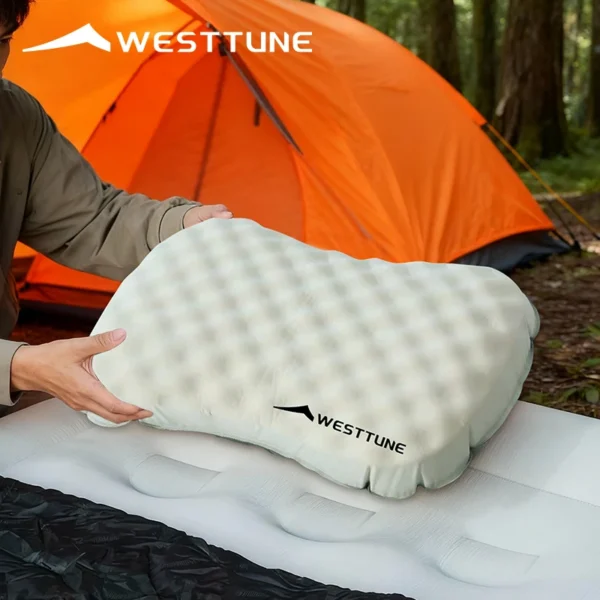 Compressible camping pillow in khaki with honeycomb fabric cover on a sleeping pad