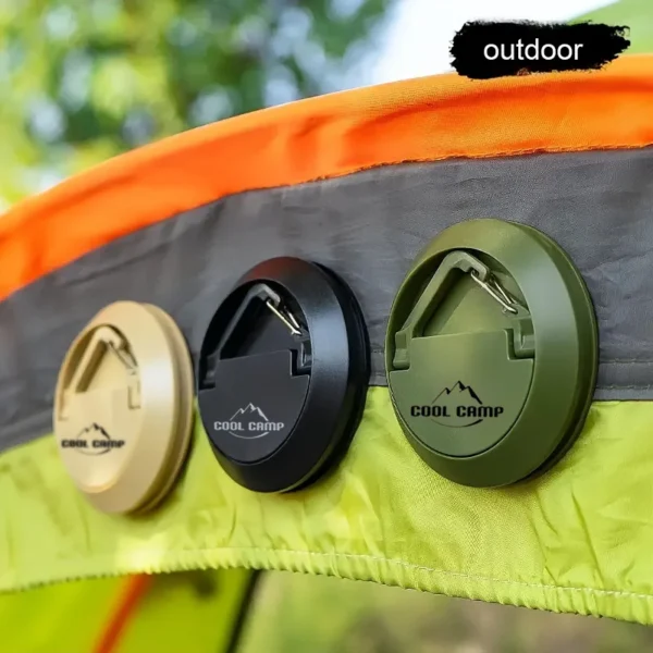 Black magnetic awning hooks holding a string of lights under a camping awning beside a tent