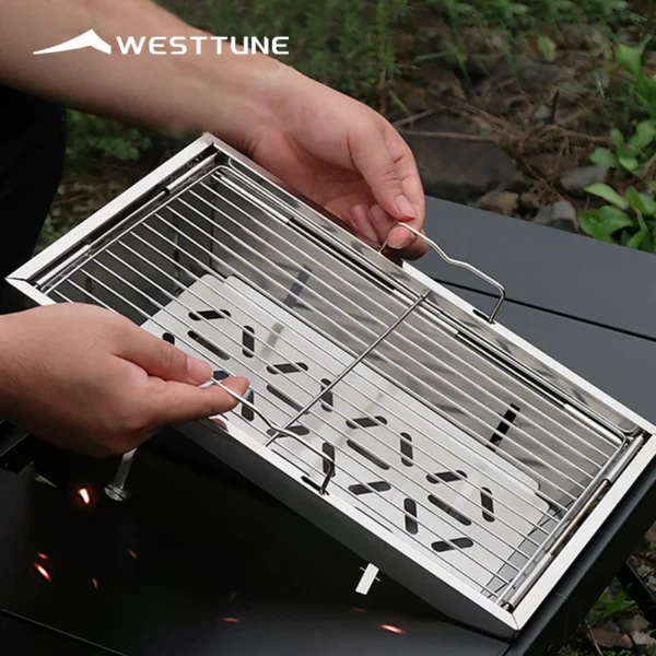 Folding charcoal camping grill in stainless steel shown opened and ready for a barbecue