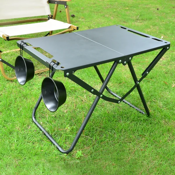 Folding beach picnic table made of carbon steel set up on the sand with snacks and drinks