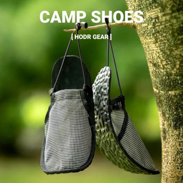 Gray ultralight camp shoes rolled up next to hiking boots outside a tent