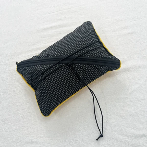 Convertible camping pillow bag shown open as a gear organizer and stuffed with clothes as a pillow