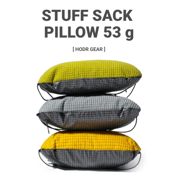 Stuff sack pillow in yellow filled with a jacket and strapped to a sleeping pad in a tent