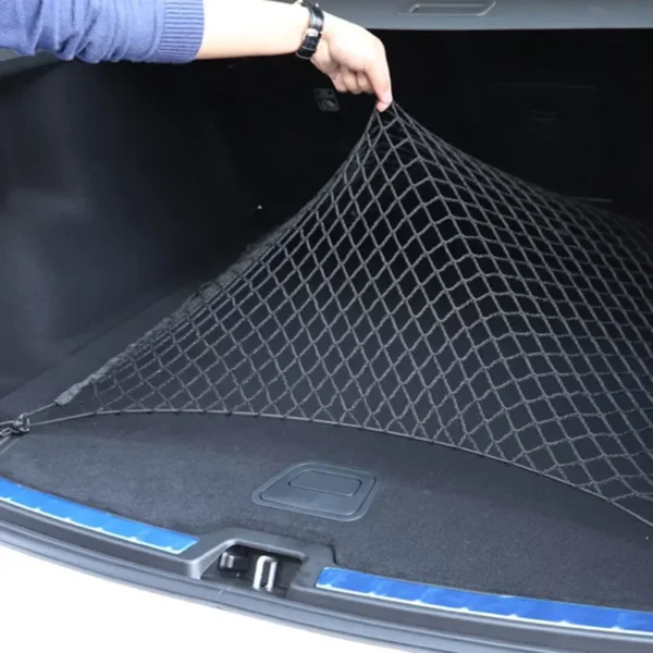 Nylon trunk cargo net hooked across a car trunk holding bags and boxes in place
